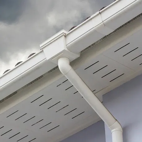 White seamless gutters and downspout installed on a residential home's soffit.